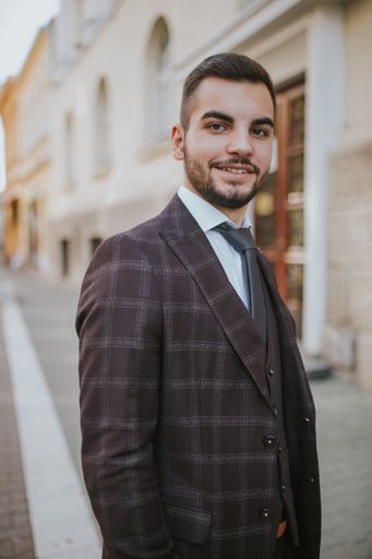 A handsome elegantly dressed Caucasian man standing outdoors