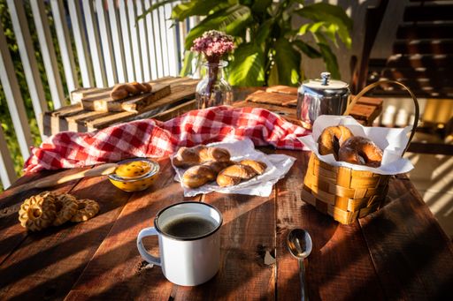 A tasty breakfast with hot coffee and freshly baked pastries on a wooden table of a rural house