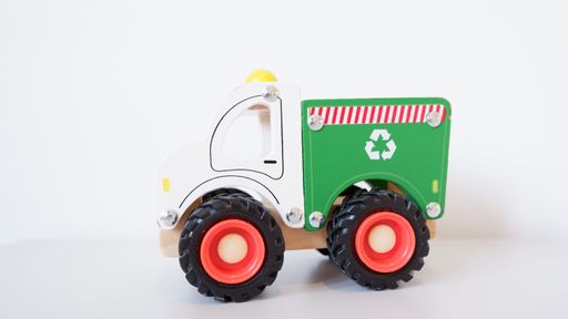 A closeup of a recycling toy truck on a white background