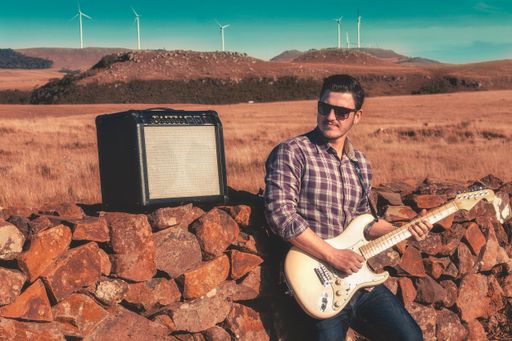 A man playing guitar in field
