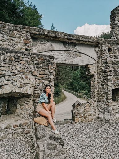 Front view of stylish young woman in front of old outpost ruin in Vuzenica, Slovenia.