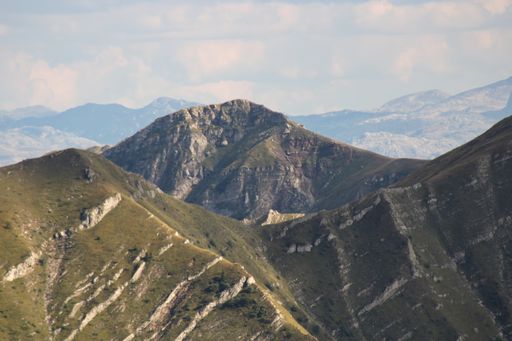 A high angle shot of mountainous landscape with layers of peaks seen under cloudy sky