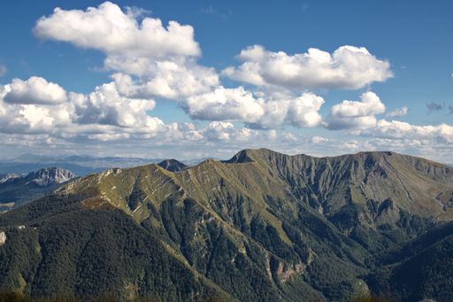A high angle shot of mountainous landscape with layers of peaks seen under cloudy sky