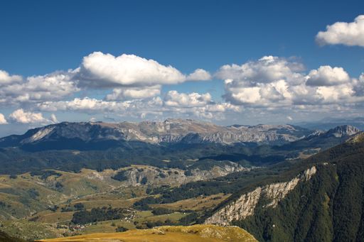 A high angle shot of mountainous landscape with layers of peaks seen under cloudy sky