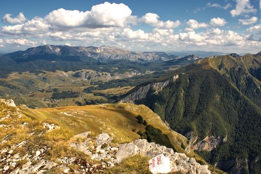 A high angle shot of mountainous landscape with layers of peaks seen under cloudy sky