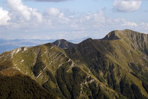 A high angle shot of mountainous landscape with peaks under sunlight