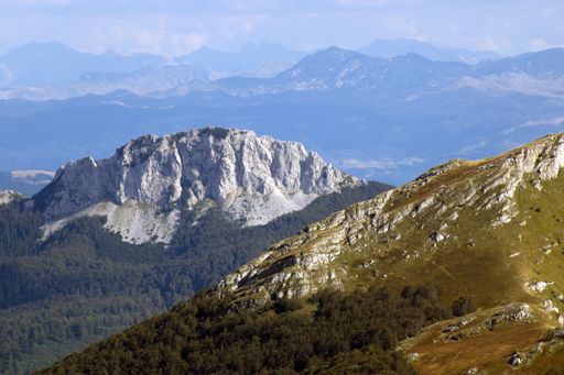 A high angle shot of mountainous landscape with layers of peaks seen under cloudy sky