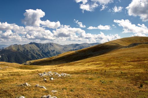 A high angle shot of mountainous landscape with layers of peaks seen under cloudy sky