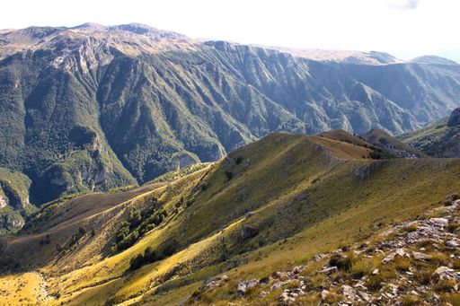 A high angle shot of mountainous landscape with layers of peaks seen under cloudy sky