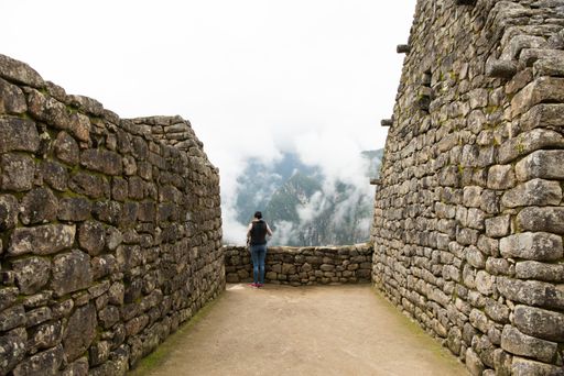 The reconstructed walls of Machu Picchu citadel surrounded by fog, in Urubamba, Peru