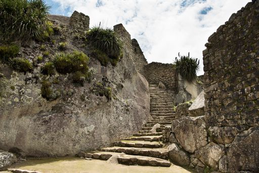 A stairway at Machu Picchu citadel against a cloudy sky in Urubamba, Peru