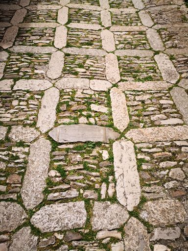 A vertical shot of the pavement in a rectangular shape arranged with stones