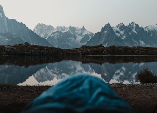 A lake reflecting the surrounding snowy mountains
