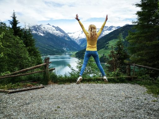 A female traveler in the air is enjoying the fantastic Speicher Durlassboden Lake, Alps, Austria