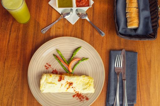 A top view of wrapped omelet with filling on a plate