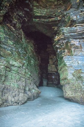 A vertical shot of the entrance of a rocky cave in As Catedrais, Galicia Spain