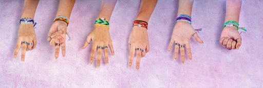 Many female hands with rings and colorful stylish bracelets