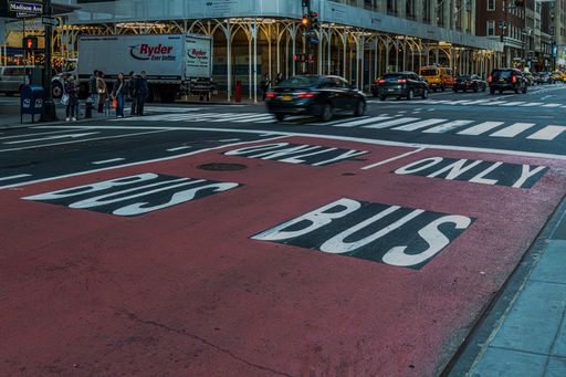 Freshly painted bus-only lane markings on a city street.