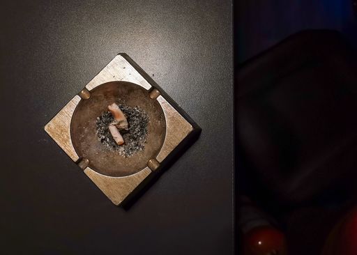 A top view of a smoked cigarette on a pile of ash in an ashtray