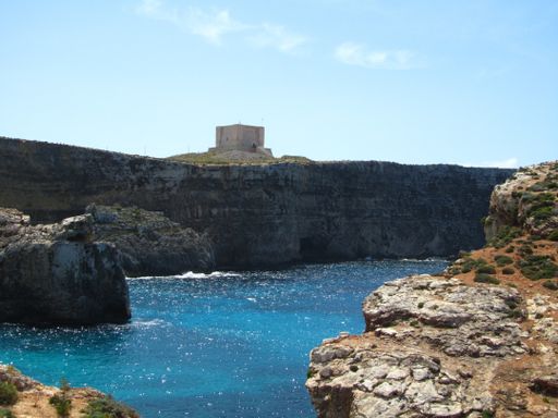 Santa Marija Tower, built by Knights Order of St John, over the cliffs and blue sea on the island of Comino, Malta. Prison in Count of Monte Cristo