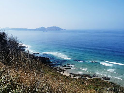 A beautiful view of the calm North Atlantic Ocean gleaming under the blue sky in Spain