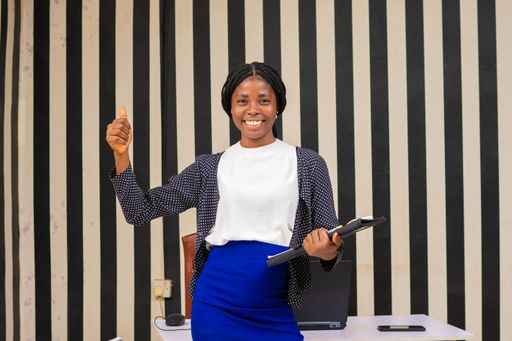 The happy woman in a business outfit holding a folder with papers.