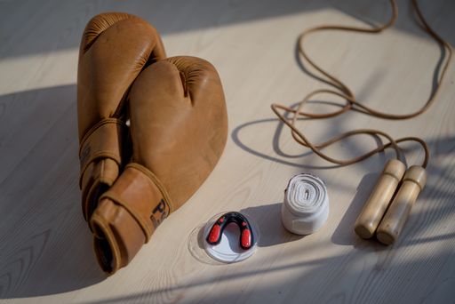 A selective focus shot of boxing gear on a wooden surface