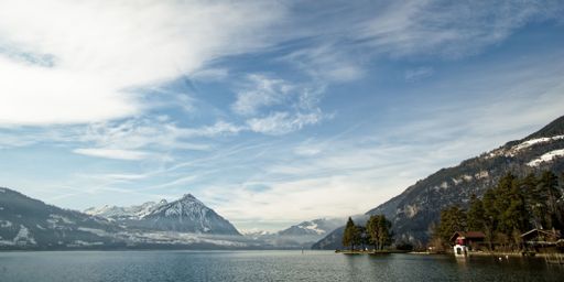 Stunning panoramic view of a beautiful lake, with a mountainous landscape in the background and old wooden houses on the shore