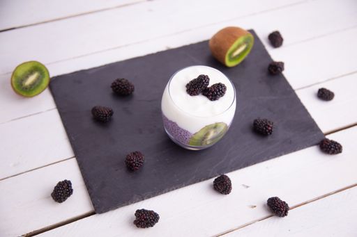 Fresh black chia pudding with blackberries and kiwi