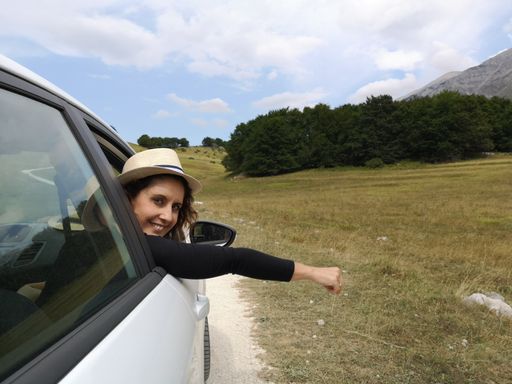 A Caucasian hiker girl looking out from the car on the mountain road in Abruzzo, Italy