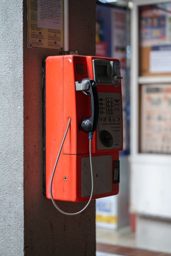 A vertical shot of a public coin telephone