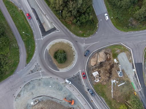 Bird's eye view of a road work of a traffic roundabout. Cars driving on the streets. Aerial, drone photography taken from above.