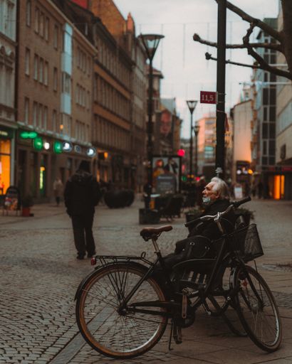 A vertical shot of an elderly male sitting outdoors in Malmo, Sweden