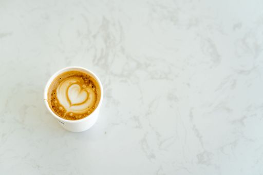 A top view of a cup of cappuccino on a marble table