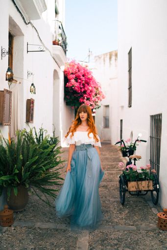 An attractive redhead model from Spain in an elegant dress posing outdoors