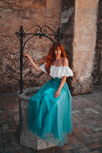 An attractive redhead model from Spain in an elegant dress posing outdoors