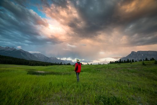 A man standing in a valley between the mountains in Western Canada.