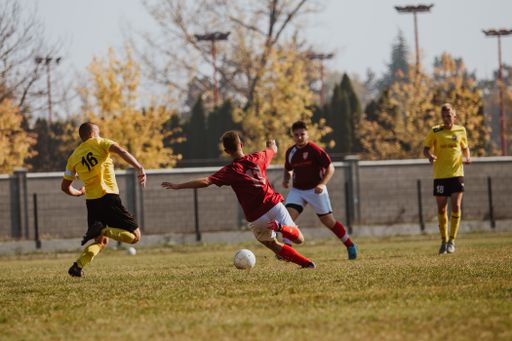 A closeup shot of beautiful handsome guys playing football on the grass in Brcko, Bosnia and Herzegovina