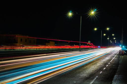 A timepiece shot of car lights at night time