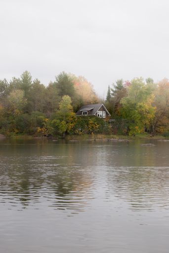 A cozy house by the lake in the autumn countryside