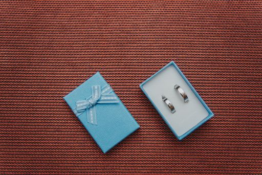 A top view of the silver precious engagement rings in the box on the brown surface