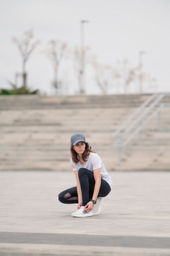 A female jogger tying her shoelaces in a park
