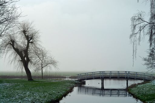 A view of the river and the wooden bridge on a cloudy day