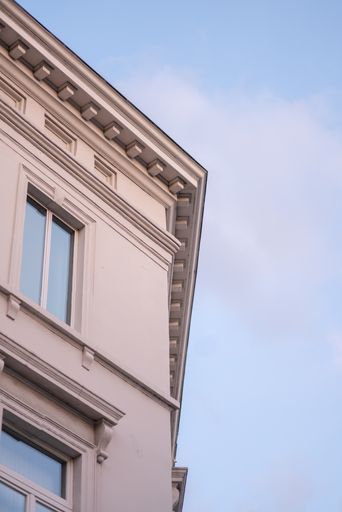 A low angle of the exterior of a contemporary building under the cloudy blue sk