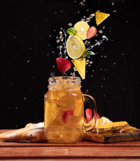 A vertical shot of delicious mix fruit juice in a glass cup on a wooden table, Isolated background
