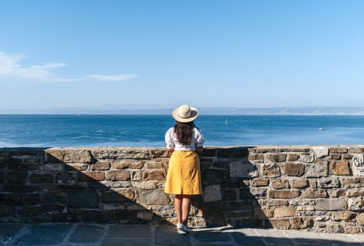 Woman standing on viewpoint overlooking the sea in Piran, Slovenia.