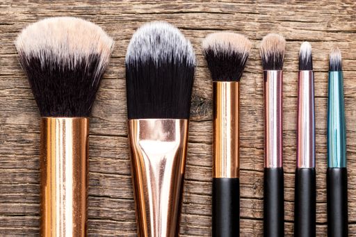 The used painting brushes of different sizes on a wooden background