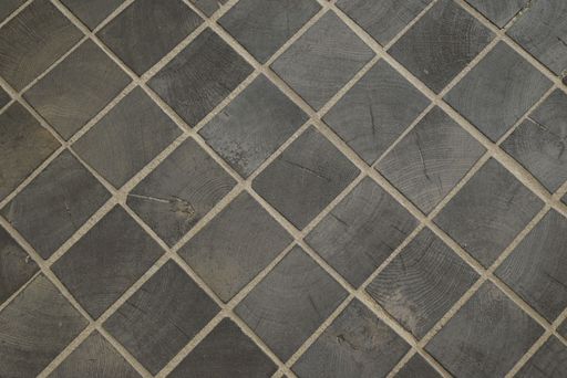 Close-up of a textured wooden tile pattern with visible grain and natural tones.