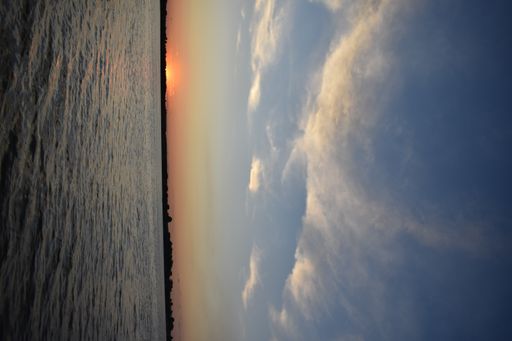 A closeup shot of a beautiful sunset over a sea under the blue sky