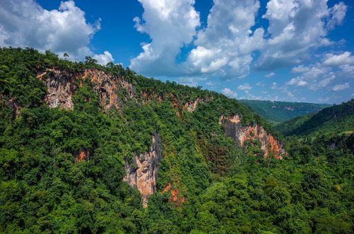 A close up shot from the top view of a mountain covered with trees in a beautiful natural place